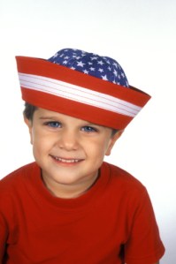 Young boy (4-5) wearing red white and blue sailor hat, smiling, portrait